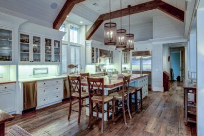 Large expensive chefs kitchen in luxury home with rough hewn wood and white cabinets.