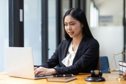 Female lawyer working on laptop in law firm.