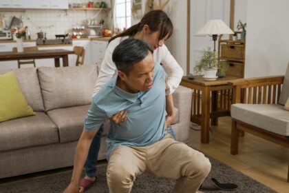 woman helps grandfather sit and rest after fall