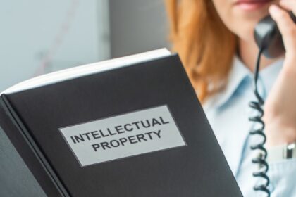 Cropped view of book with intellectual property lettering with blurred businesswoman on background,