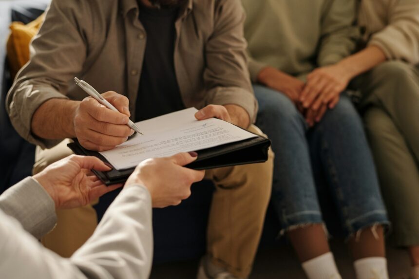 Man signing custody contract at meeting with social worker