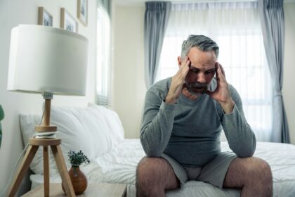 Caucasian senior older depressed man sitting alone in bedroom at home.