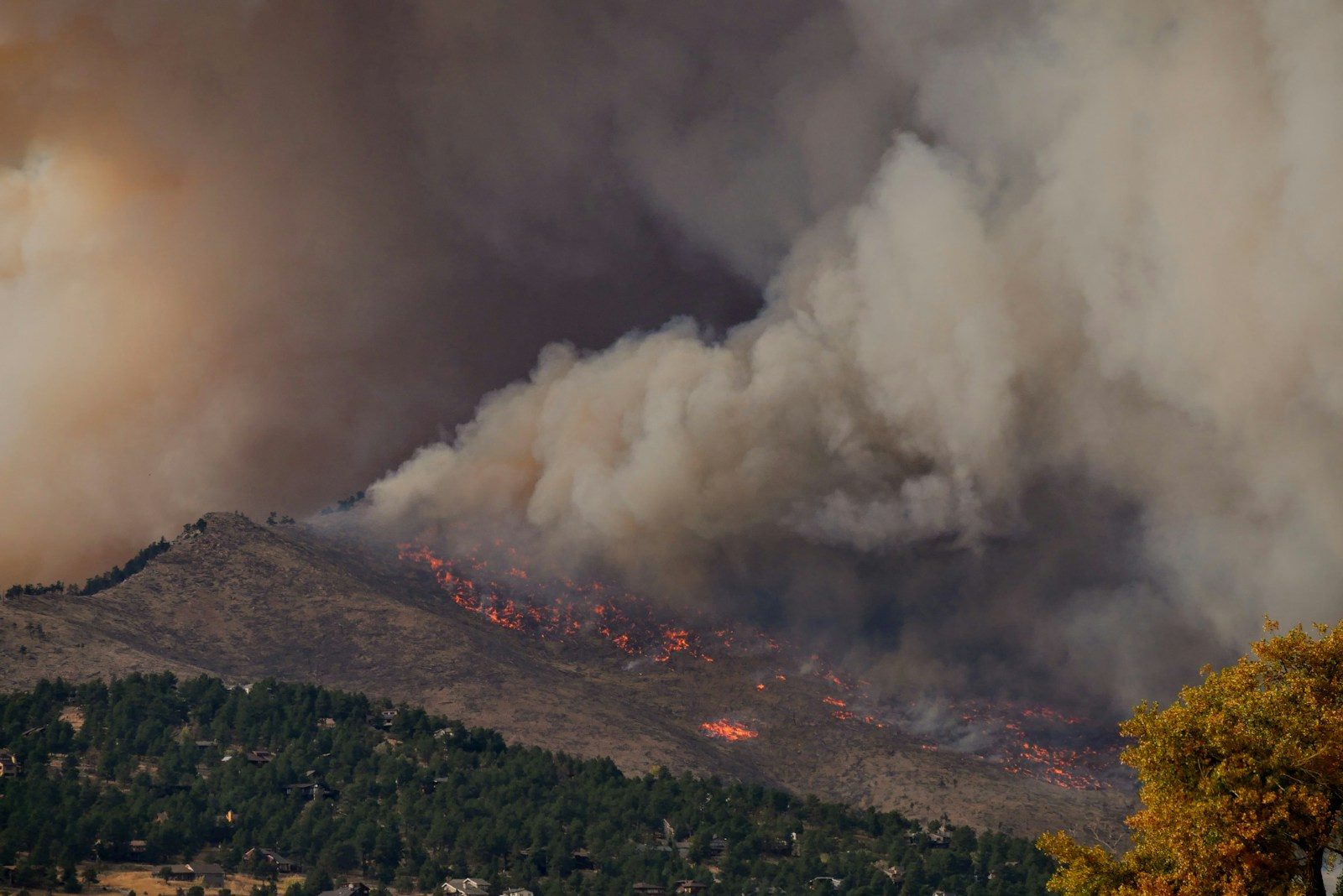 white smoke coming from a gray clouds, wildfire damage