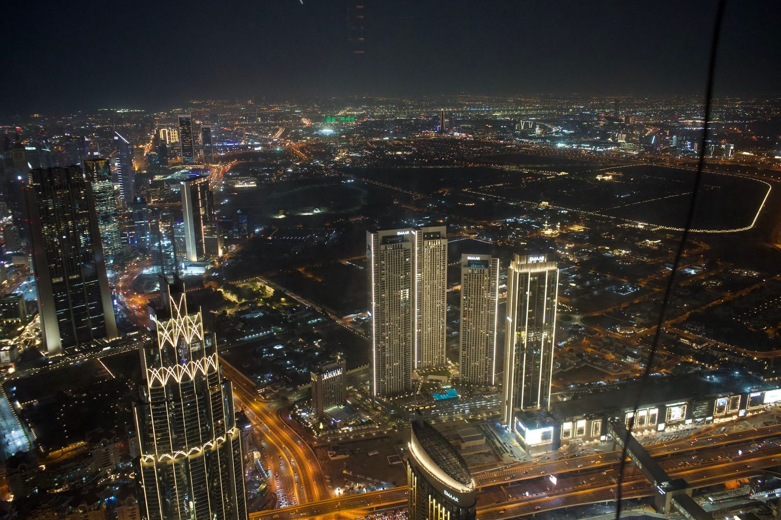 Stunning aerial view of Dubai's illuminated skyline at night, showcasing modern architecture.