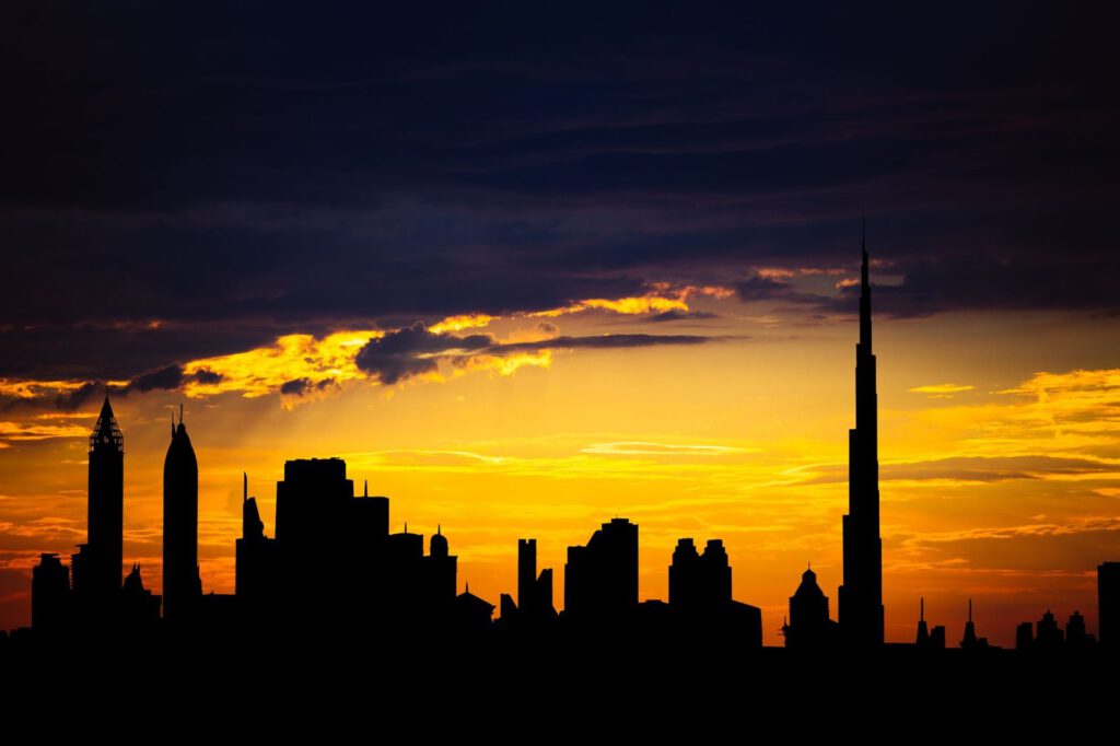 Captivating silhouette of Dubai's skyline with vibrant sunset colors and Burj Khalifa dominating the scene.