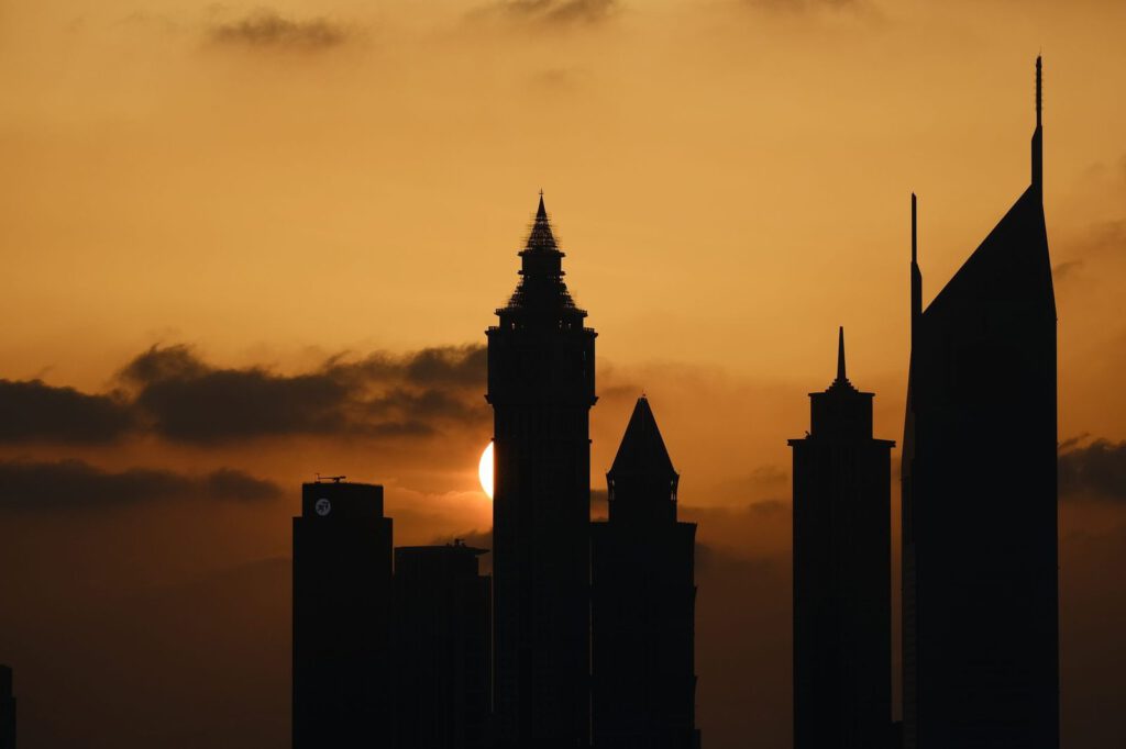 Silhouette of Dubai's iconic skyline against a dramatic sunset.