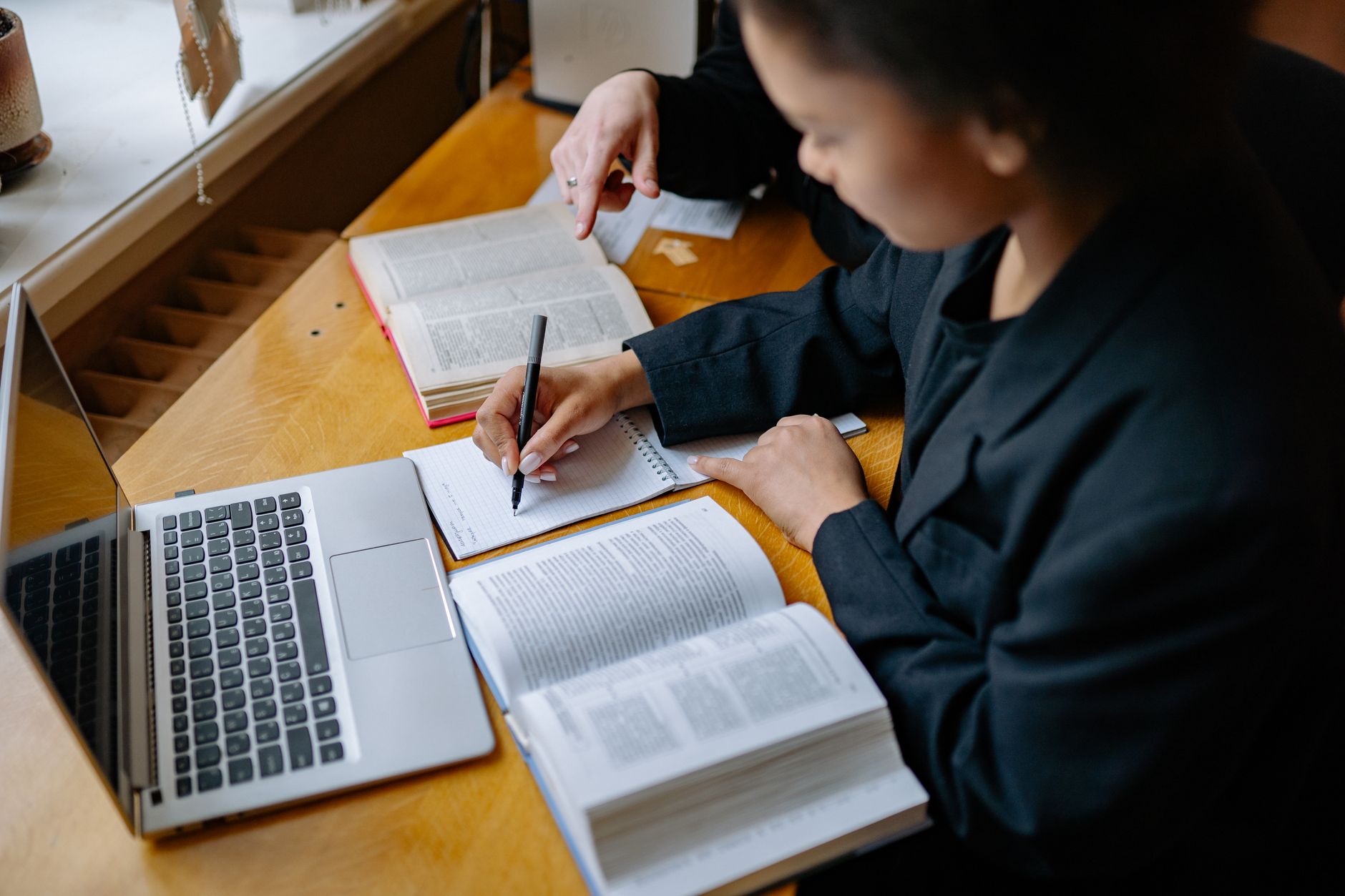 Paralegal student studying law books and notes at a desk while preparing for an ABA-approved paralegal program