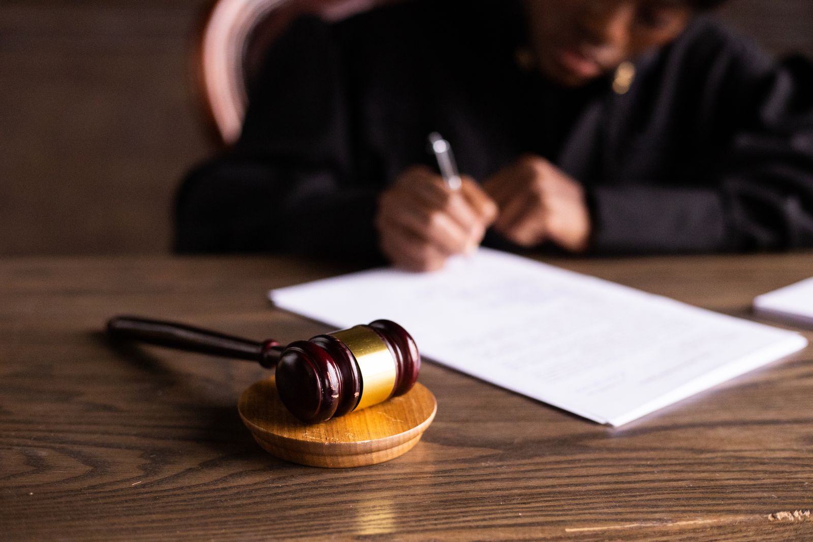 Judge signing court papers next to a gavel