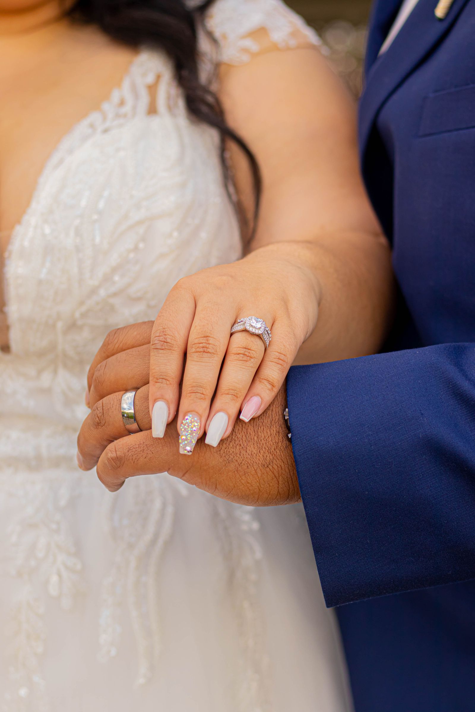 Couple holding hands wearing wedding rings