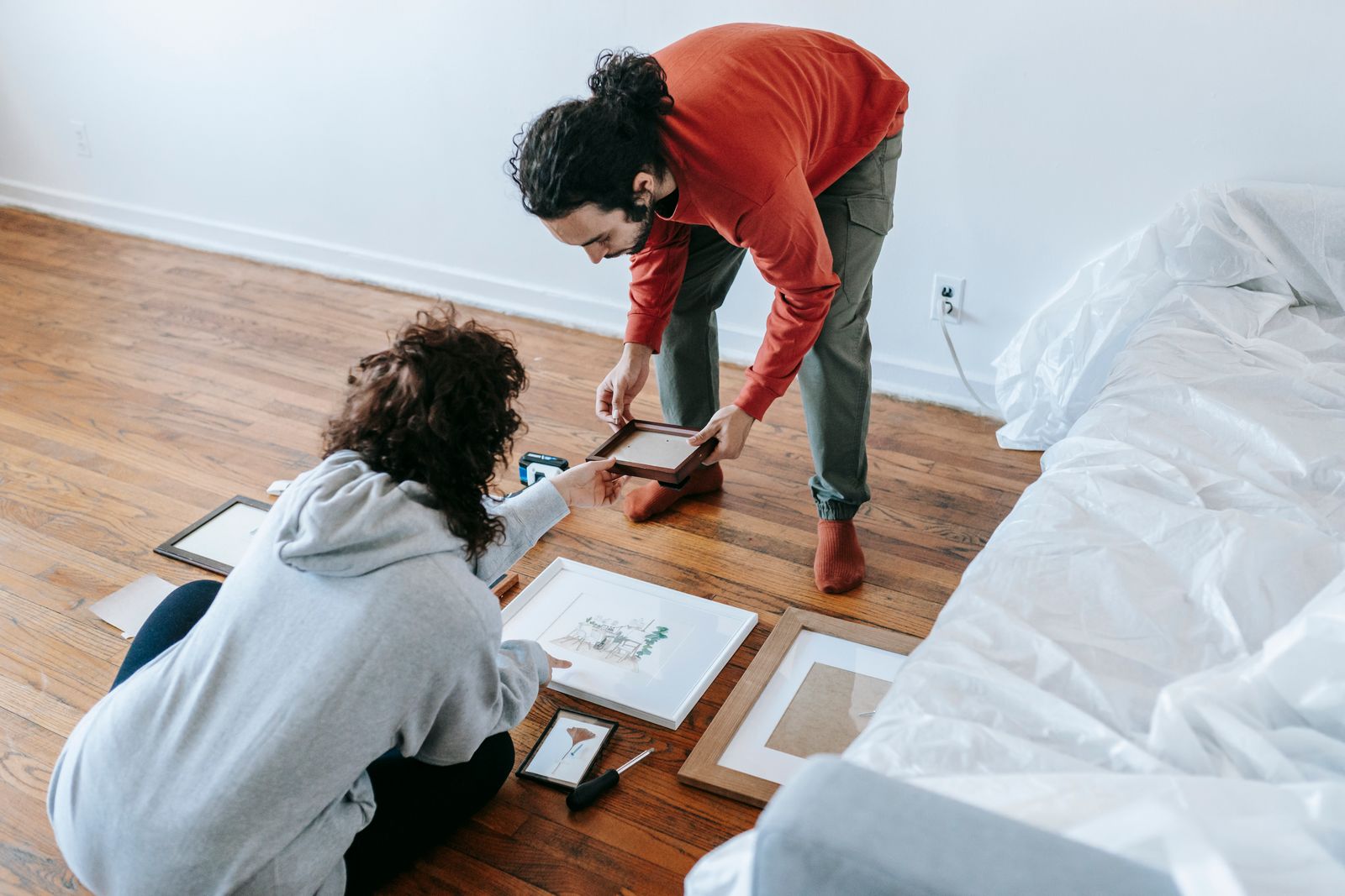 Couple arranging picture frames in their shared home