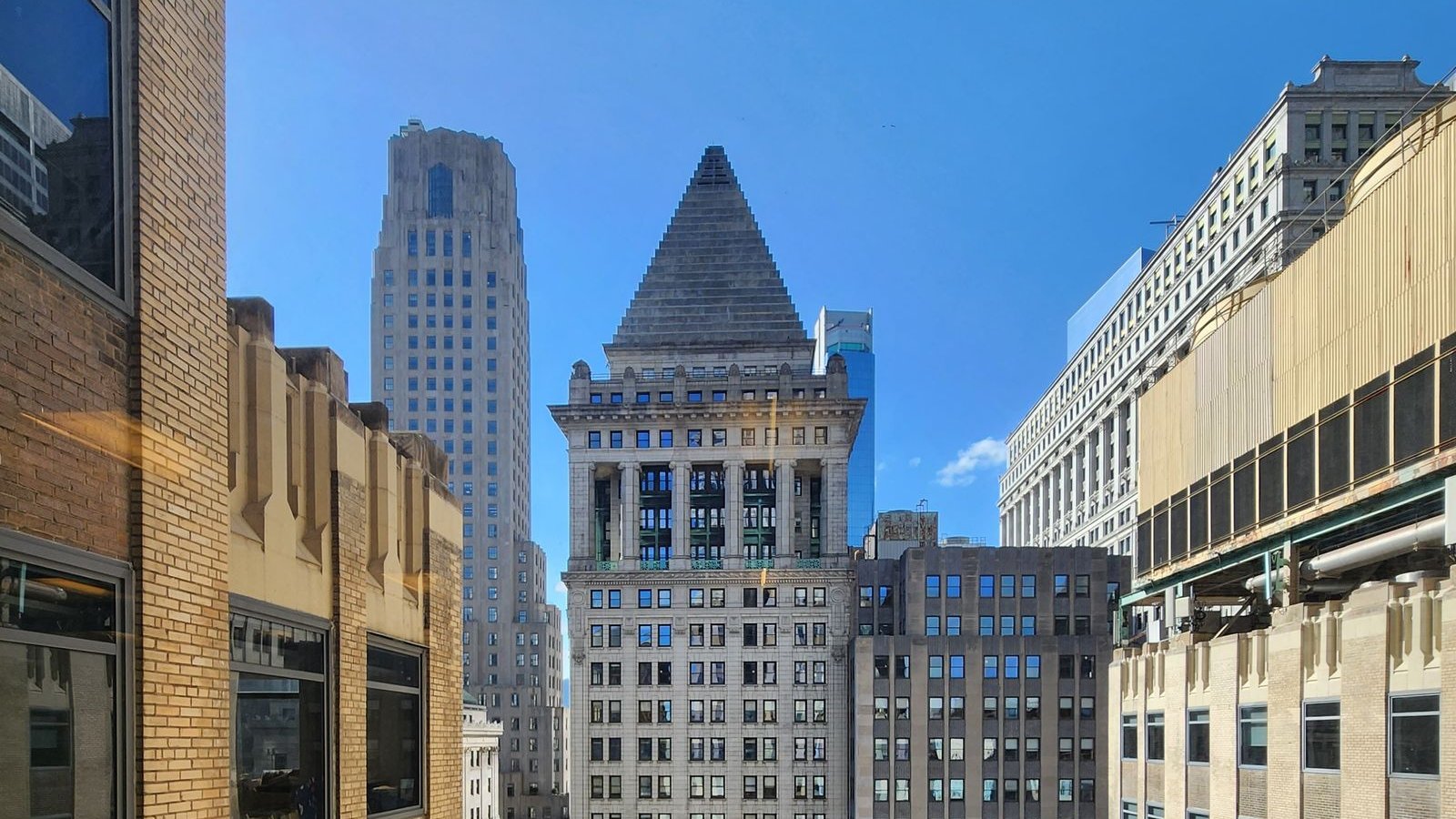 Stone skyscrapers of Lower Manhattan's Financial District, including the stepped pyramid top of 14 Wall Street
