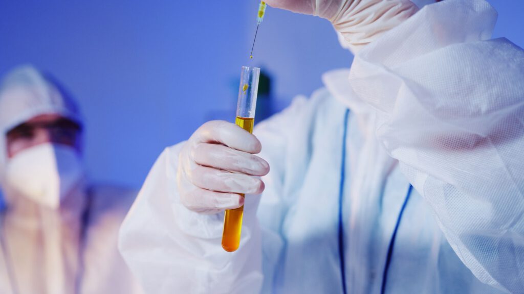 Forensic DNA analyst pipetting samples into test tubes in a crime laboratory