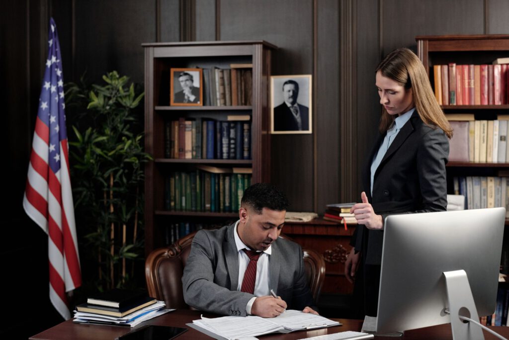 Paralegal reviewing case documents and a laptop at an office desk