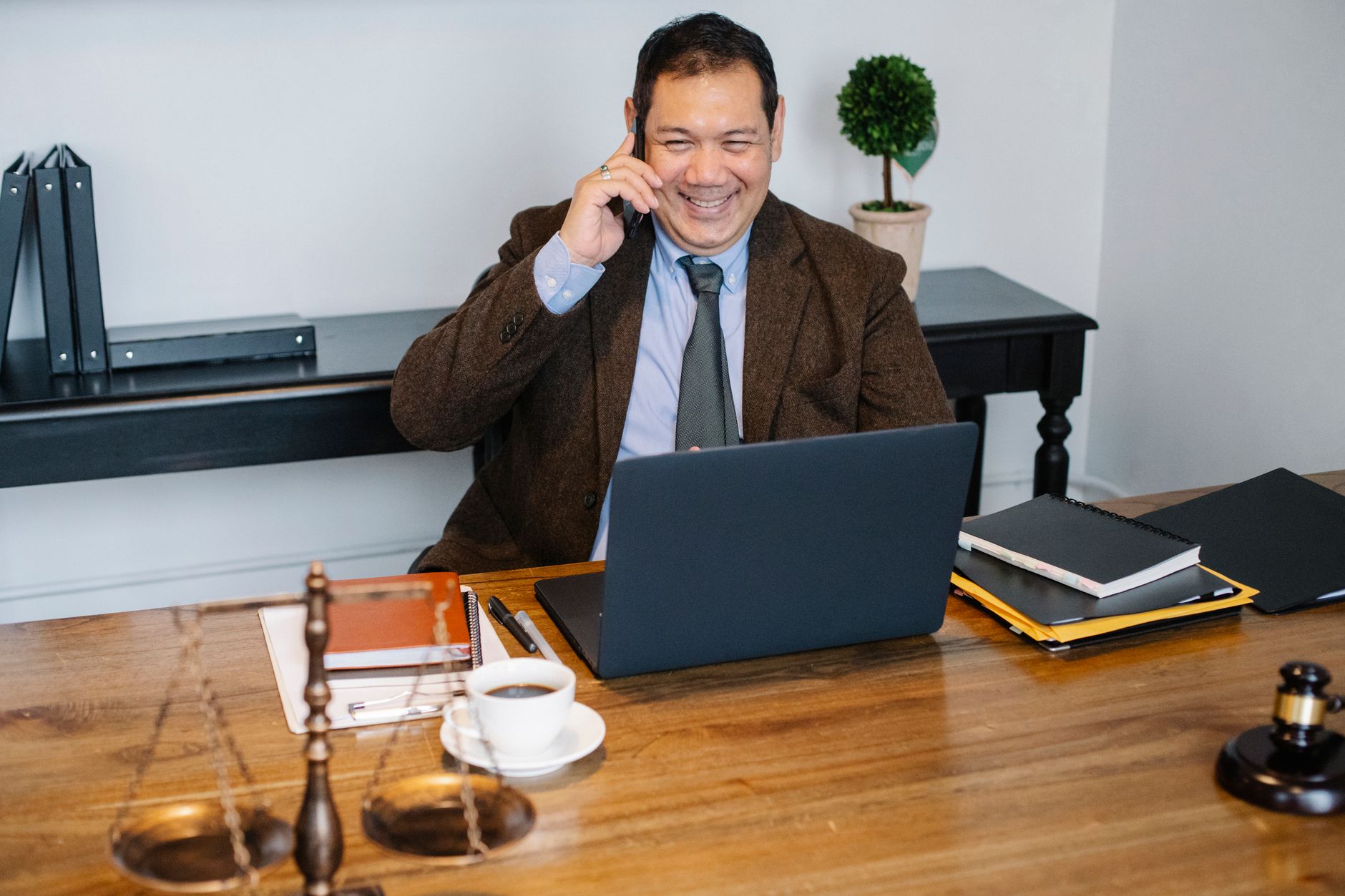 Lawyer working remotely on a video call from a laptop at a home desk with case files