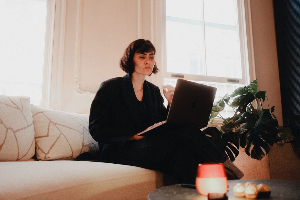 Remote paralegal working on a laptop at a home office desk with legal documents beside her