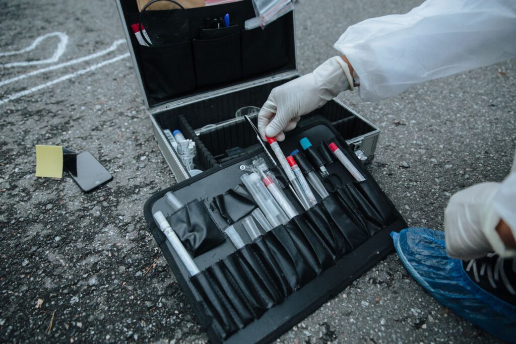 Crime scene investigator taking a tool from an evidence kit