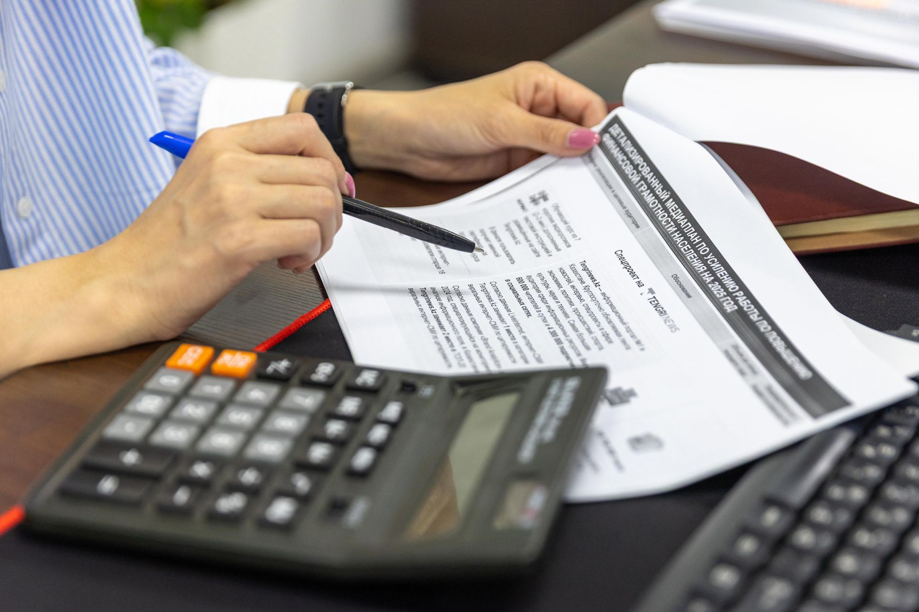 Forensic accountant reviewing financial statements and spreadsheets at a desk
