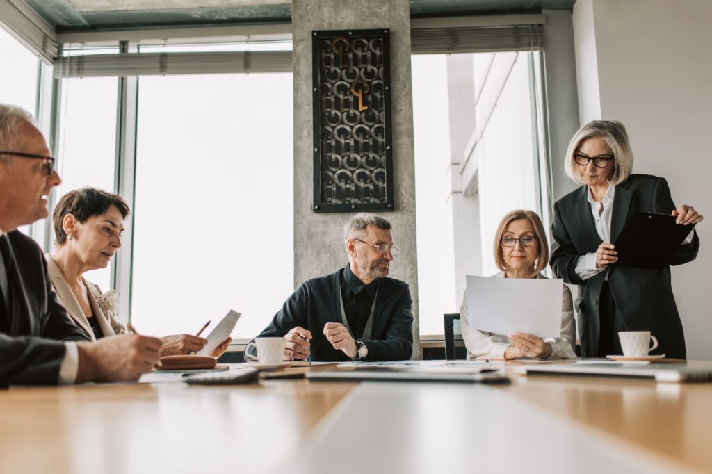 Senior executives and a company lawyer in discussion around a boardroom table